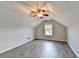 Attic bedroom featuring light walls, luxury vinyl flooring, a ceiling fan, and natural light at 2506 Creek Station Dr, Buford, GA 30519