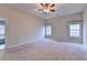 Spacious bedroom with neutral carpet, ceiling fan, and natural light from windows at 2506 Creek Station Dr, Buford, GA 30519