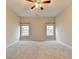 Large bedroom with neutral carpet, ceiling fan and natural light from two windows at 2506 Creek Station Dr, Buford, GA 30519