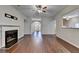Open living room with fireplace, hardwood floors, archway, and ceiling fan at 2506 Creek Station Dr, Buford, GA 30519