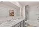 Well-lit bathroom featuring a double vanity with marble countertop and a shower-tub combo at 8588 Secretariat Dr, Lithonia, GA 30058