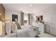 Bright bedroom featuring a white bed set with plenty of pillows and a matching white dresser and a large window at 8588 Secretariat Dr, Lithonia, GA 30058