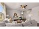 Bright living room features a ceiling fan, large windows, and comfortable gray sofas at 8588 Secretariat Dr, Lithonia, GA 30058