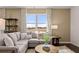 Cozy living room featuring a plush gray sectional sofa, area rug, and large sunlit window at 8588 Secretariat Dr, Lithonia, GA 30058