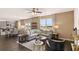Open-concept living room with modern gray furniture, a large window, and an eat-in kitchen at 8588 Secretariat Dr, Lithonia, GA 30058