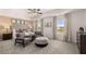 Comfortable main bedroom with sitting area, soft carpet, and a decorative ceiling fan at 8588 Secretariat Dr, Lithonia, GA 30058