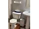 Cozy bathroom with toilet, pedestal sink, trash can and wood-look flooring at 179 Silver Arrow Cir, Austell, GA 30168