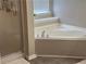 Modern bathroom featuring a large corner bathtub and tiled flooring, bathed in natural light at 179 Silver Arrow Cir, Austell, GA 30168