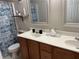 This bright bathroom features double vanity sinks, wood cabinets, and a blue patterned shower curtain at 179 Silver Arrow Cir, Austell, GA 30168