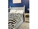Comfortable bedroom with zebra print comforter, white nightstand, and blue accent wall at 179 Silver Arrow Cir, Austell, GA 30168