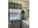 This functional laundry room features a gray pattern curtain, ironing board, and laundry appliances at 179 Silver Arrow Cir, Austell, GA 30168