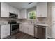 Bright kitchen with stainless steel appliances, white cabinets, marble countertops, and hardwood floors at 1940 Matthew Way, Lithonia, GA 30058