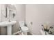 A well-lit half bathroom featuring a pedestal sink and toilet with neutral decor at 5300 Willow Park Blvd, Atlanta, GA 30349