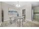 A dining room with a glass table and seating for four under a chandelier, with kitchen in background at 5300 Willow Park Blvd, Atlanta, GA 30349