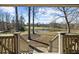 Peaceful backyard pond view with mature trees, accessed from a charming staircase with wood railings at 1511 Broadnax Mill Road, Loganville, GA 30052