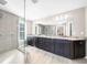 Bright bathroom featuring a glass-enclosed shower, dual sinks, dark cabinets, and ample counter space at 1511 Broadnax Mill Road, Loganville, GA 30052