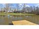 Wooden dock extends into the pond, providing a peaceful spot amidst the green landscape at 1511 Broadnax Mill Road, Loganville, GA 30052