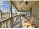 Inviting covered front porch with ceiling fan and wooden rocking chairs overlooking the property at 1511 Broadnax Mill Road, Loganville, GA 30052