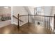 Upstairs hallway with wood flooring, decorative railing, and view into bedroom at 1511 Broadnax Mill Road, Loganville, GA 30052