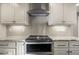 Bright kitchen with white cabinets, backsplash, stainless steel stove and marble countertops at 1511 Broadnax Mill Road, Loganville, GA 30052