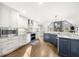 Open-concept kitchen with white cabinets, stainless steel appliances, and a dark blue island with marble countertop at 1511 Broadnax Mill Road, Loganville, GA 30052