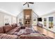 Living room featuring a stone fireplace, brown leather sofa and lots of windows at 1511 Broadnax Mill Road, Loganville, GA 30052