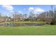 Scenic view of the pond, reflecting the house and surrounded by a green lawn at 1511 Broadnax Mill Road, Loganville, GA 30052