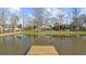 Scenic pond reflecting the house, complemented by lush landscaping and mature trees at 1511 Broadnax Mill Road, Loganville, GA 30052