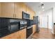 Modern kitchen features stainless steel appliances, wooden cabinets, black counters and tiled backsplash at 250 Pharr Road Northeast Ne Rd # 1813, Atlanta, GA 30305