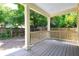 Inviting back porch with white columns, a wooden fence, and a tranquil view of the backyard at 301 Fortune St, Atlanta, GA 30312