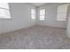 Empty bedroom showcasing plush carpeting, a neutral color scheme, and natural light from three windows at 301 Fortune St, Atlanta, GA 30312