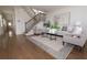 Bright living room featuring hardwood floors, modern decor, a staircase, and ample natural light at 301 Fortune St, Atlanta, GA 30312