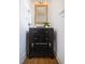 Stylish powder room with dark wood vanity, a framed mirror, modern lighting, and hardwood floors at 301 Fortune St, Atlanta, GA 30312