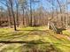 The backyard has trees, green grass and a wooden playhouse at 31 Mariner Se Way, Acworth, GA 30102