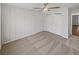 Neutral bedroom with panel wall, beige carpet, ceiling fan, and a double-door closet at 31 Mariner Se Way, Acworth, GA 30102