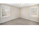 Cozy bedroom with neutral walls, soft carpet, and two windows at 3898 Rosedale Ln, Douglasville, GA 30135