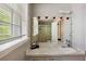 Bathroom with gray walls, window with blinds, and a large mirror decorated with decorative red flower accents at 1387 John Robert Dr, Morrow, GA 30260