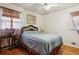 Bedroom with hardwood floors, wicker headboard, sheer curtains, and a ceiling fan for added comfort at 1387 John Robert Dr, Morrow, GA 30260