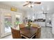 Bright dining area with backyard views, ceiling fan, and a mix of white cabinetry with tile backsplash at 1387 John Robert Dr, Morrow, GA 30260