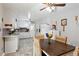 Bright dining area with backyard views, ceiling fan, and a mix of white cabinetry with tile backsplash at 1387 John Robert Dr, Morrow, GA 30260