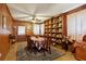 Wood-paneled dining room featuring built-in shelving, a ceiling fan, and ample seating for entertaining at 1387 John Robert Dr, Morrow, GA 30260