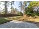 Expansive backyard featuring a mature tree line and a concrete patio area, perfect for outdoor living at 4149 Indian Lake Cir, Stone Mountain, GA 30083