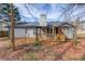 Rear exterior featuring the covered porch, set among beautiful mature trees and natural landscaping at 629 Granite Ln, Loganville, GA 30052