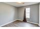 Empty bedroom with gray walls, wood look flooring, and a window at 629 Granite Ln, Loganville, GA 30052