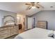 Primary bedroom with en-suite bathroom, large dresser, vaulted ceiling and ceiling fan at 629 Granite Ln, Loganville, GA 30052