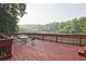 Spacious outdoor deck with a dining table, chairs, and a view of the tranquil lake at 783 Lost Creek Cir, Stone Mountain, GA 30088