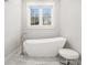 Bright bathroom showcasing a modern free-standing tub, elegant fixtures, and a stool at 1005 W Kingston Dr, Atlanta, GA 30342