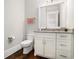 Powder room with granite countertops, white cabinetry, and dark wood flooring at 1005 W Kingston Dr, Atlanta, GA 30342