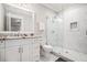 Modern bathroom with a glass shower door, marble countertops, and white cabinets at 1005 W Kingston Dr, Atlanta, GA 30342