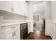 Butler's pantry featuring white cabinetry, hardwood flooring, and a built-in wine cooler at 1005 W Kingston Dr, Atlanta, GA 30342